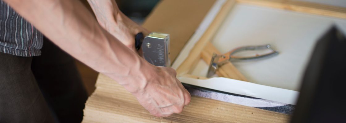 hands stretching the canvas on the stretcher